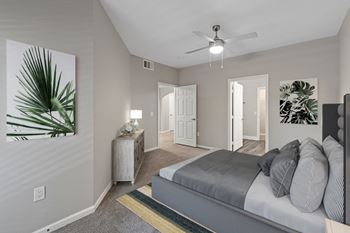 A bedroom with a bed, nightstands, and a ceiling fan.